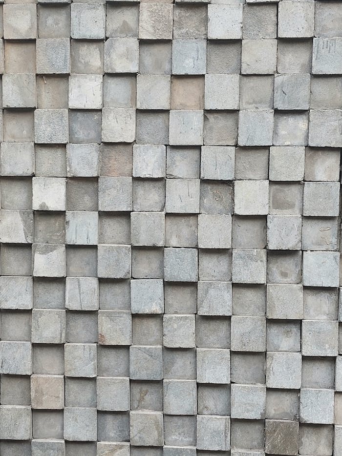 Close-up of a textured stone tile wall with a geometric pattern, perfect for backgrounds.